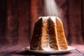 Icing sugar pouring on italian pandoro christmas cake with warm natural light up with warm night giving a feeling of  artisanship Royalty Free Stock Photo