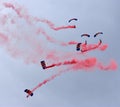 Parachute Display Team desending with red smoke. Royalty Free Stock Photo