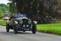 Vintage 1928 Bentley 4 being driven though English village.