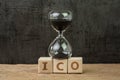 ICO, Initial Coin Offering for crypto currency to buy and sell on public concept, sandglass or hourglass on wooden cube block with