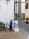 Icod de Los Vinos, Tenerife, Spain - April 12th, 2022, A man applies the new paint to the building wall in the old town. Royalty Free Stock Photo