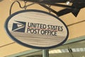 Oval decorative United States Post Office sign hanging from ceiling