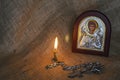 Icon of the Archangel Michael with silver and gilding, a pectoral cross and a burning candle Royalty Free Stock Photo