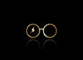 Icon of a golden round glasses, minimal style, isolated on black background