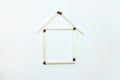 Icon of the house. The house is laid out of matches on a white background. The concept of building and buying a house. Royalty Free Stock Photo