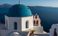 Iconic blue-domed church with pink bell tower and the Aegean Seain Greece Royalty Free Stock Photo