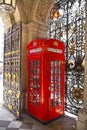 Iconic British red telephone box and beautiful metal gate lace Royalty Free Stock Photo