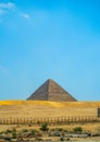 Iconic Egyptian pyramid structure emerging from sandy desert terrain with weathered limestone blocks Royalty Free Stock Photo