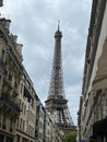 Iconic Eiffel Tower seen between two city buildings. Paris, France.