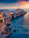Iconic evening cityscape of Vieste - coastal town in Gargano National Park, Italy, Europe. Gorgeous spring sunset on Adriatic sea. Royalty Free Stock Photo