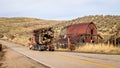 Logging truck speeds past an Idaho rusted barn