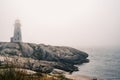 Iconic Peggy's Cove Lighthouse on a foggy day, Nova Scotia, Canada Royalty Free Stock Photo