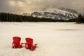 The iconic red chairs in the snow in front of the Two Jack lake in Banff National Park Royalty Free Stock Photo