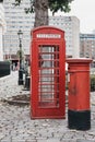 An iconic red telephone box next to a red post box in St Katharine Docks, London.