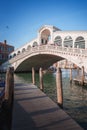 Iconic Rialto Bridge spanning the Grand Canal in Venice, Italy amidst bustling cityscape. Royalty Free Stock Photo