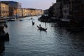 Iconic scene along the Venetian Canals of gondoliers in late afternoon sun.