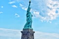 Iconic Statue of Liberty stands prominently against a backdrop of blue sky