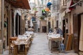 the iconic Strada Arco Basso in the historic old town of Bari Vecchio with a woman presenting fresh pasta for sale in street