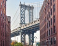 Iconic view of Manhattan Bridge from Washington Street. Red brick street buildings leading to the bridge at dusk. Brooklyn. NYC, Royalty Free Stock Photo