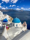 Iconic view over blue domed church in Santorini Greece