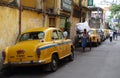 The iconic yellow ambassador taxi Kolkata and a hand pulled rickshaw