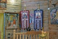 Icons in an ancient temple with candles lit under them in a candlestick.