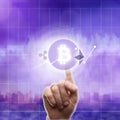 Icons bitcoin ripple, ethereum on an ultra purple background of the city. The hand touches the bitcoin icon