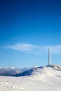 Icy cellular base station antenna covered with snow. Cell site tower on moutain hill. Telephone network transceivers and