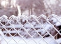 Icy fence against the snow covered forest. Frosty day Royalty Free Stock Photo