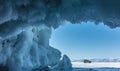 An icy grotto in the rock. Rows of fancy icicles hang from the vault.