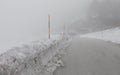 Icy mountain road with poor visibility due to thick fog and snow Royalty Free Stock Photo