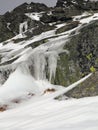 Icy Mountain Rocks. Rocks Covered With Green Coating. Icicles Hanging From the Rocks. Royalty Free Stock Photo