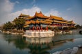 Icy pond in front of the traditional Chinese temple with bamboo roof and red columns in Penglai, Yantai, Shandong, China, blue sky