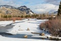 Icy river in winter sunshine with mountain backdrop. Winter in Wyoming