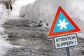 An icy road in winter with a sign Attention slippery Royalty Free Stock Photo