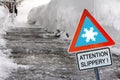 An icy road in winter with a sign Attention slippery Royalty Free Stock Photo