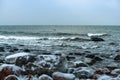 Icy rocks on the beach, sea shore in ice and snow in winter Royalty Free Stock Photo