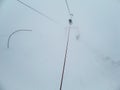 Icy ski lift with inexperienced skier in in thick fog. Skiers in the fog on a snowy mountain Royalty Free Stock Photo