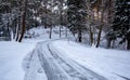 Icy slippery dangerous road in winter in the forest. Snowy mountains snowstorm. Royalty Free Stock Photo