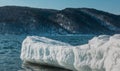 An icy snow ledge juts out into the river.