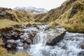 An icy stream flows with glacial waters from the mountains in Cusco`s Sacred Valley. Peru