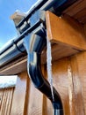 Icycles hanging from guttering on the side of a wooden house. Hovden, Norway, Feb 2023.