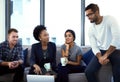 Id like to explore this new trend. a group of colleagues having an informal meeting on a sofa at work. Royalty Free Stock Photo