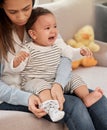 Id rather be barefoot. a young baby girl crying while her mother changes her clothes at home. Royalty Free Stock Photo