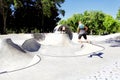 A lone boy performs stunts at a skateboard park