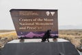 Black labrador retriever dog at Craters of the Moon National Monument sign