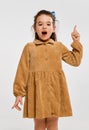 Idea. Beautiful little cute girl, kid in stylish dress emotionally posing against grey studio background. Concept of Royalty Free Stock Photo