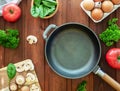 Idea for breakfast. Empty cast-iron frying pan and ingredients for omelette or scrambled eggs. Eggs, mushrooms, tomato, spinach Royalty Free Stock Photo