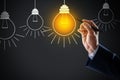 Idea concept. Businessman drawing glowing light bulb on virtual screen Royalty Free Stock Photo