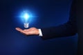 Idea concept. Businessman with glowing light bulb on dark background Royalty Free Stock Photo